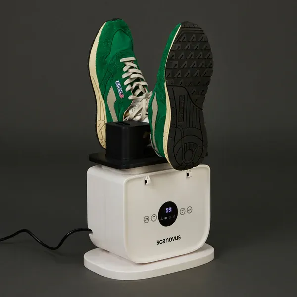 Automatic ironing machine with its shoe drying rack